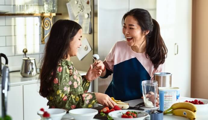 Femme et enfant riant en préparant un repas